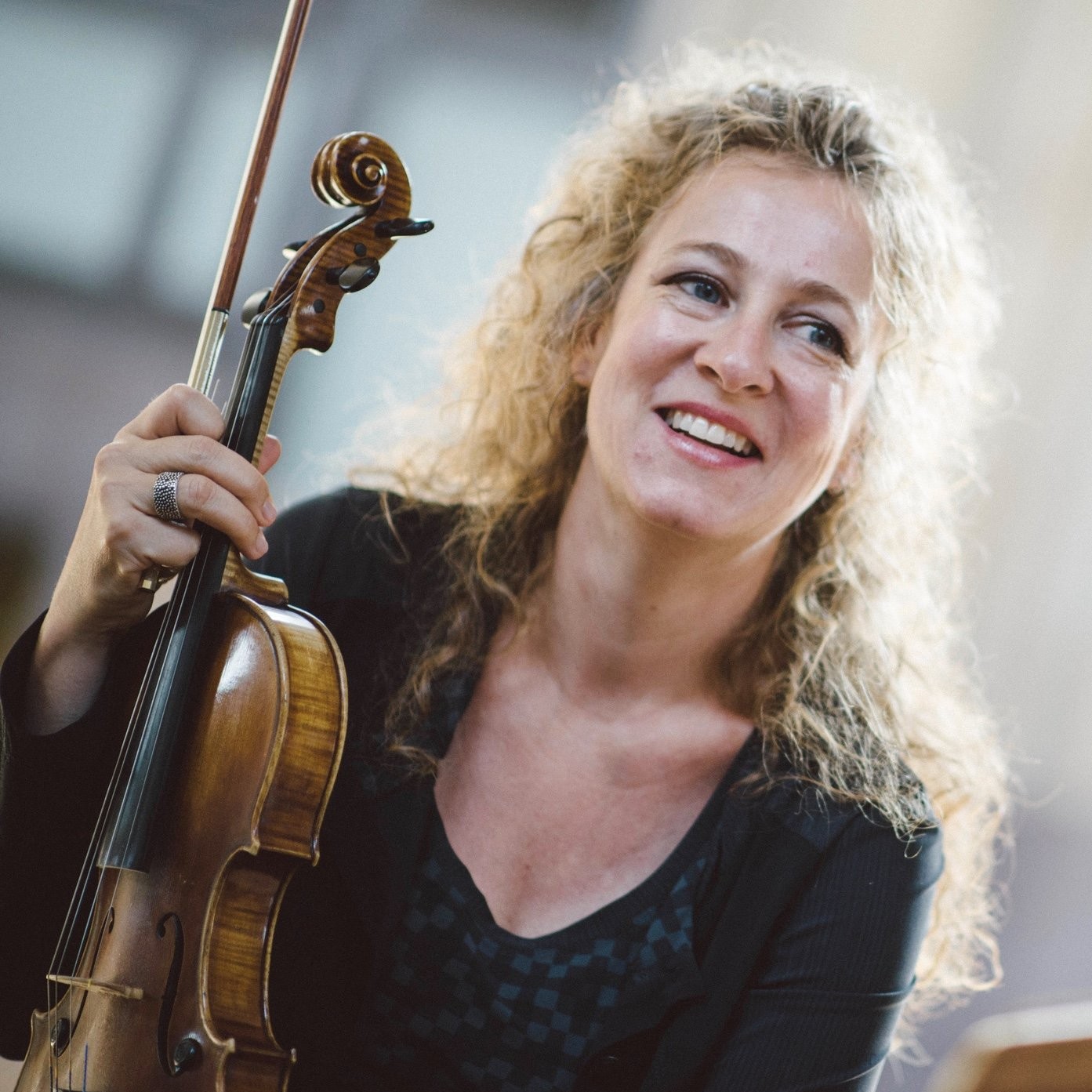 Musician smiling while holding her violin